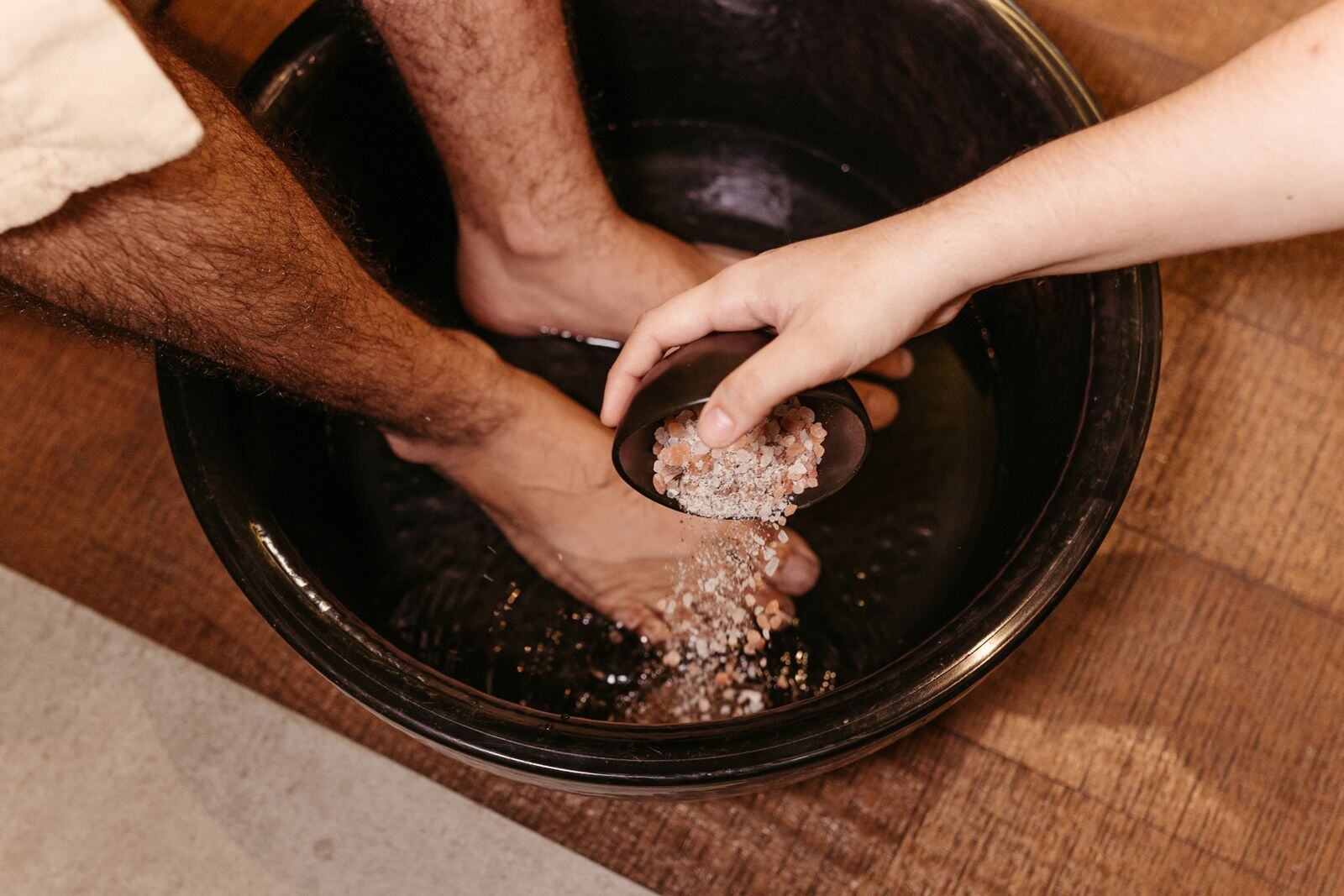 Warm herbal foot soak with mineral salts before a foot reflexology session in Flushing