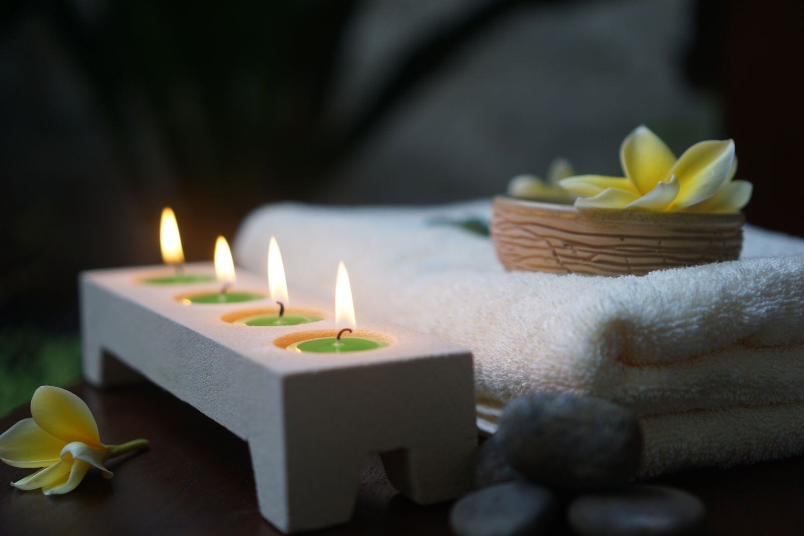 Candles, rolled towels and smooth stones prepared for a relaxing massage